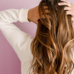 Girl running her hands through her hair after hair cut & colour in manchester hairdressers