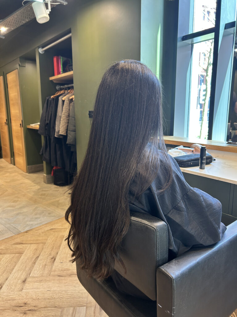Smooth glossy straightened hair after a salon smoothing treatment shown from behind