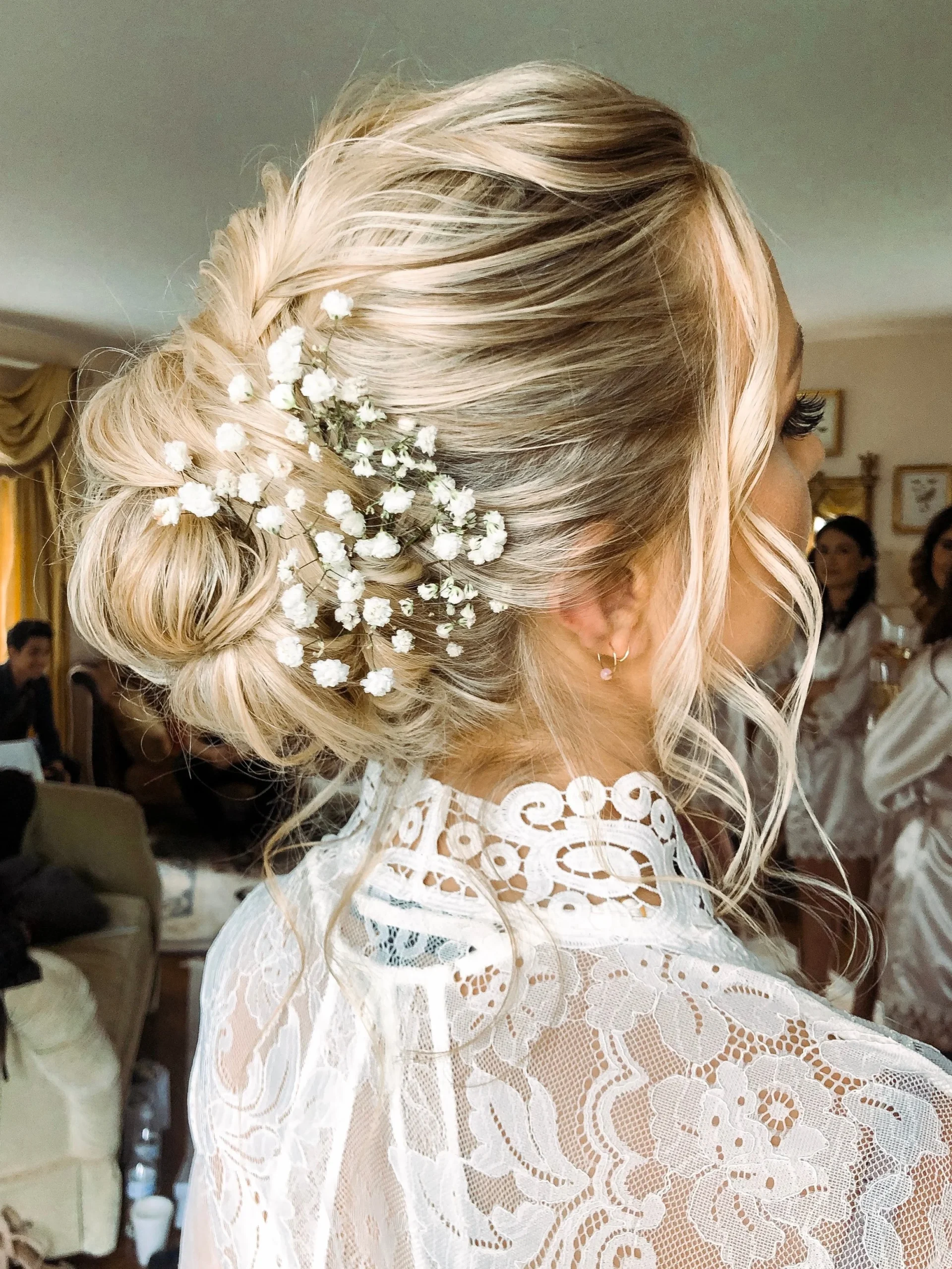 beautiful wedding updo bun with flowers on blonde balayaged hair.