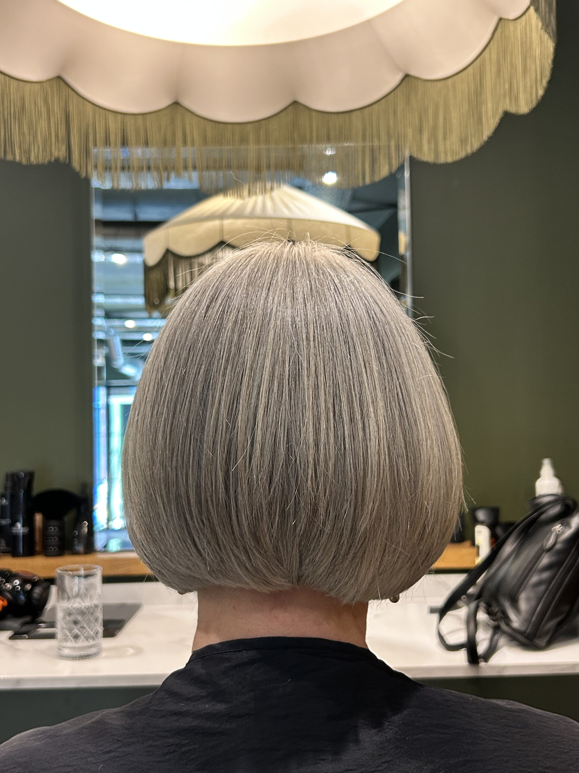Stylist sectioning hair with foils to blend grey strands at the temples