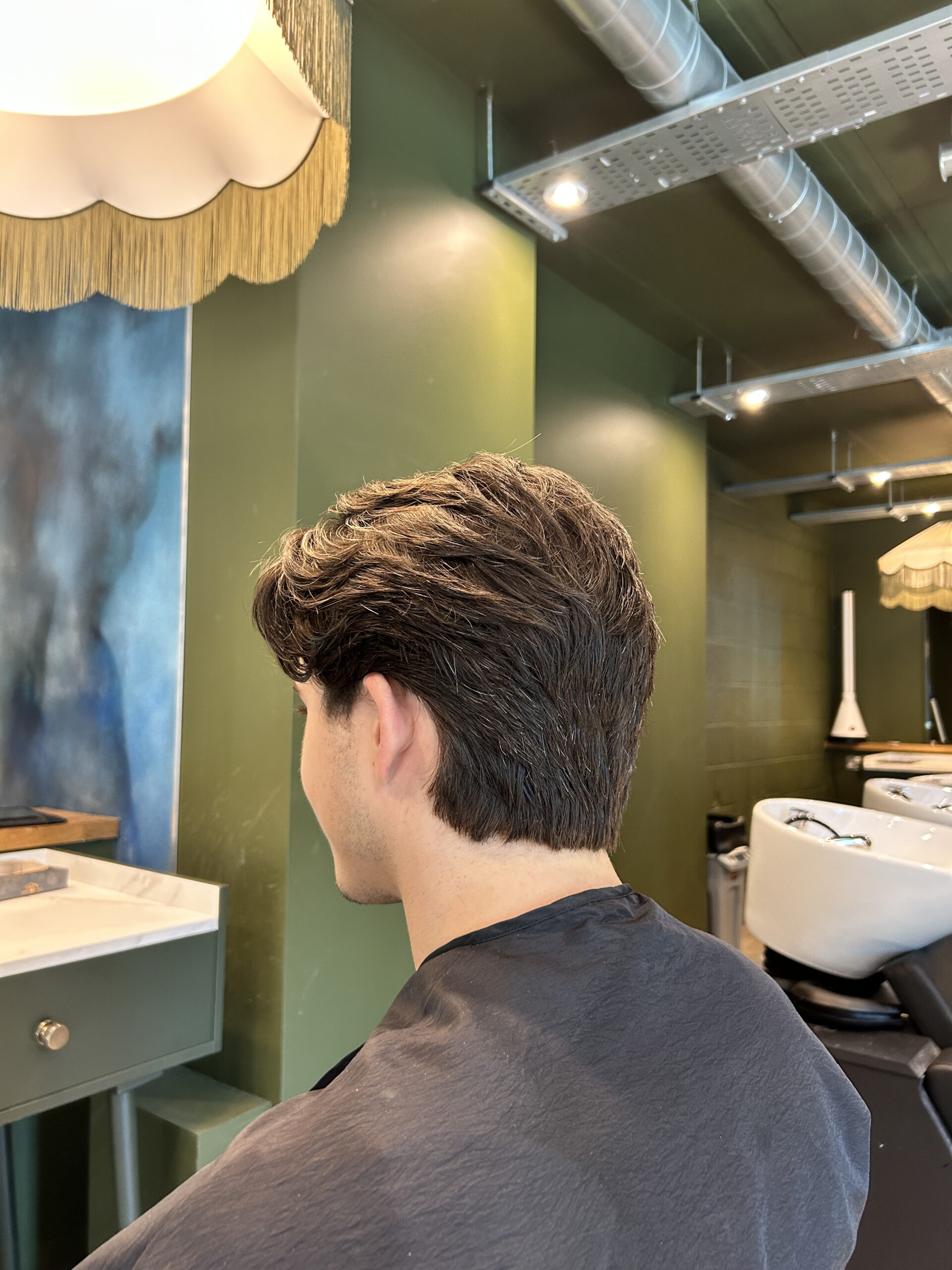 Man with a thick, dark brown textured haircut at a Manchester hair salon