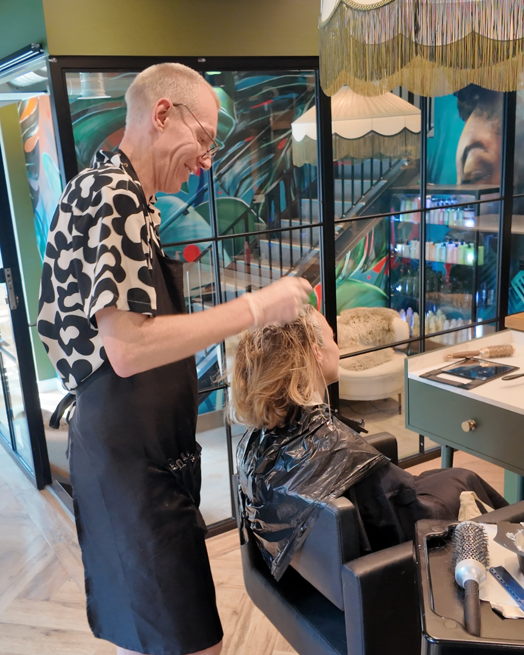 Hairdresser Guy colouring a ladies hair in a salon in Manchester
