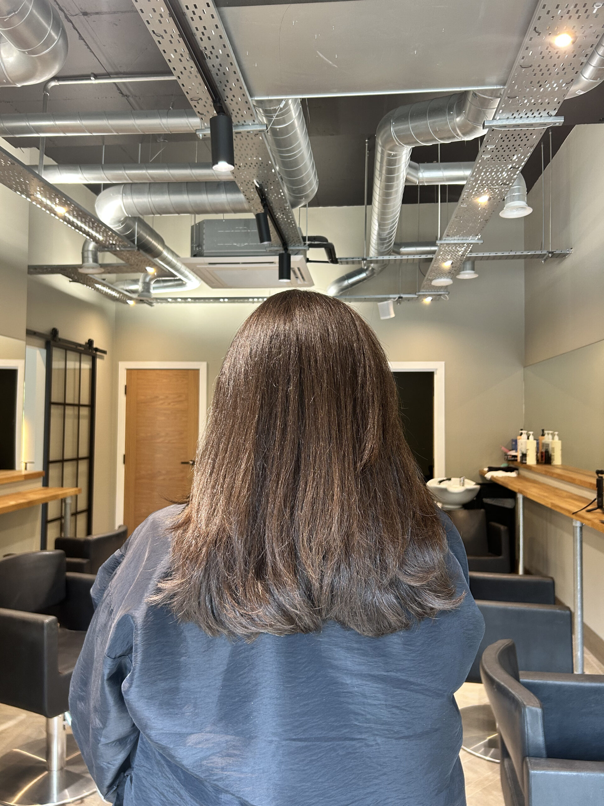 Womans black just below shoulder length hair cut and styled at David Rozmans salon